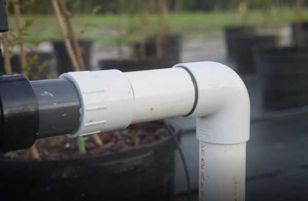Close-up of PVC irrigation pipe fitting in a nursery — Pierson Supply irrigation fittings and connectors