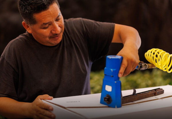 A fernery worker sealing up a box of ferns